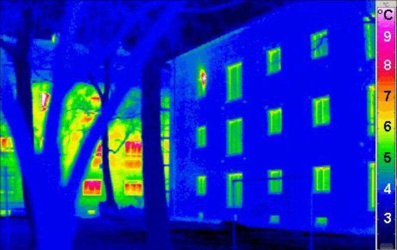 Thermal image of well insulated housing in the foreground and poorly insulated housing behind.